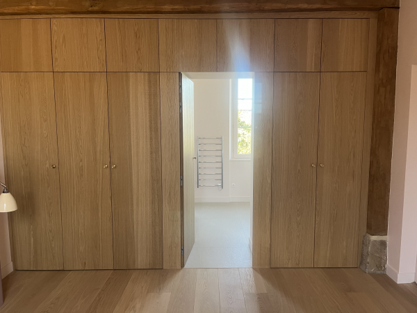 Réalisation d’un dressing sur mesure avec façade en chêne et éclairage intégré dans une chambre parentale 
