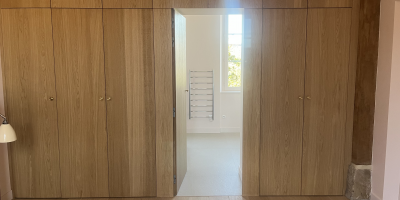 Réalisation d’un dressing sur mesure avec façade en chêne et éclairage intégré dans une chambre parentale 